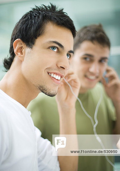 Jugendliche Männer  die Kopfhörer hören