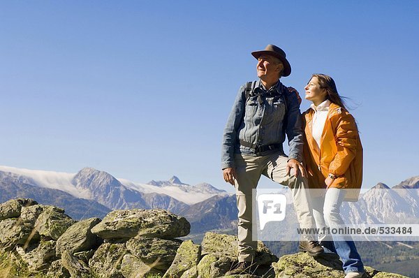 Paar in den Bergen  auf Felsen stehend