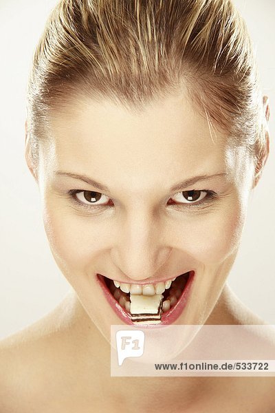Junge Frau mit Süßigkeiten zwischen den Zähnen