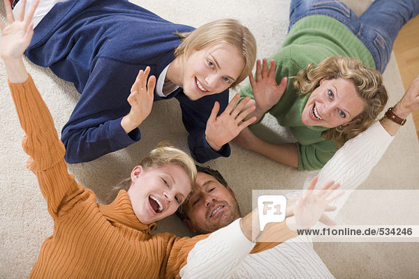 Familie auf dem Boden liegend im Wohnzimmer  lächelnd  erhöhte Aussicht