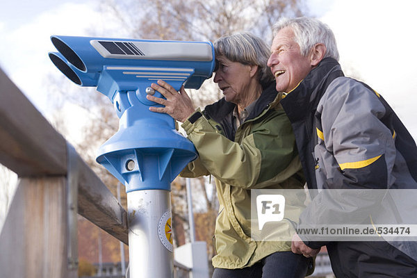 Seniorenpaar  Frau schaut durchs Teleskop  Seitenansicht