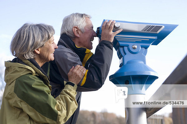 Seniorenpaar  Mann schaut durchs Teleskop  Seitenansicht