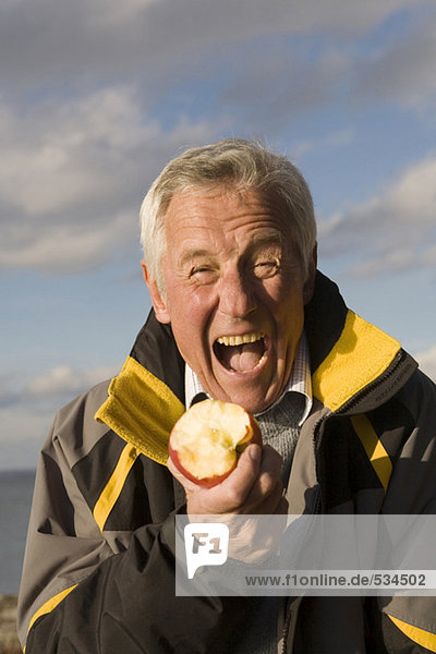 Senior erwachsener Mann beim Apfelessen