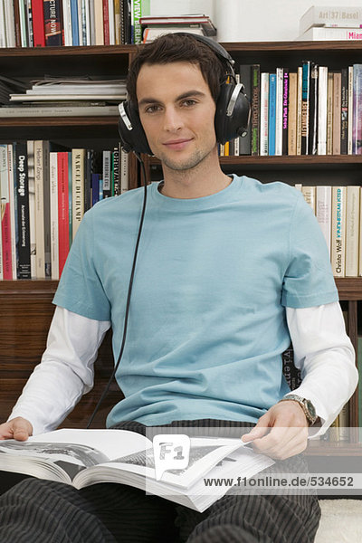 Young man sitting on floor  wearing headphones
