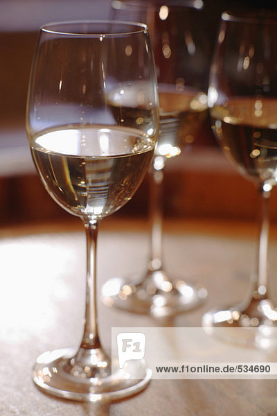 Weißwein im Glas auf Weinfass  Nahaufnahme