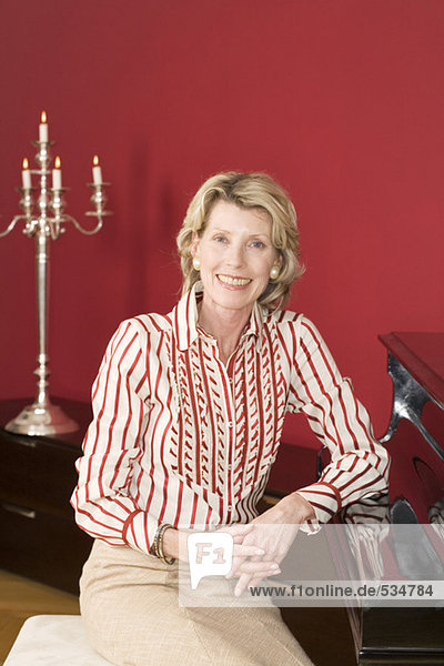 Reife Frau am Klavier sitzend,  lächelnd,  Portrait