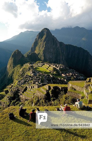 Tourists looking at old ruins on mountain  Inca Ruins  Machu Picchu  Cusco Region  Peru