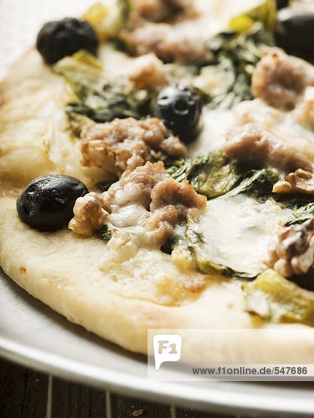 Pizza mit Hackfleisch  Oliven  Spinat und Käse (Close Up)