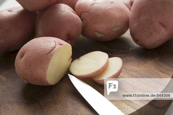 Rote Kartoffeln  eine angeschnitten  auf Holzteller