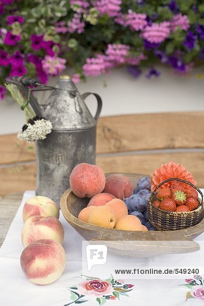 Sommerliches Obststilleben auf Tisch vor dem Haus