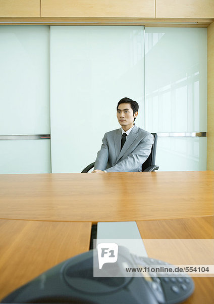 Geschäftsmann am Konferenztisch sitzend