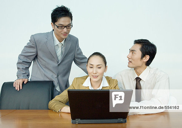 Drei Geschäftspartner mit Laptop