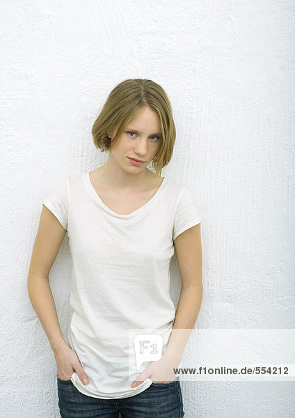 Teenage girl standing with hands in pockets  portrait