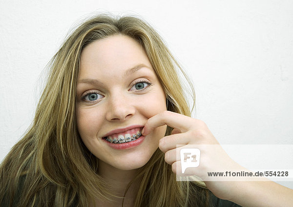 Teenager-Mädchen berührt Zahnspange  Portrait