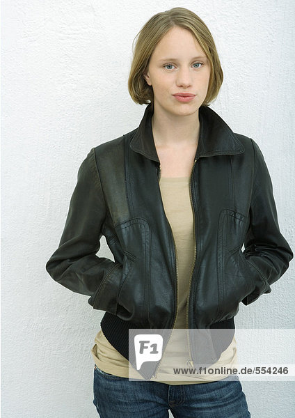Teenage girl standing with hands in pockets  portrait
