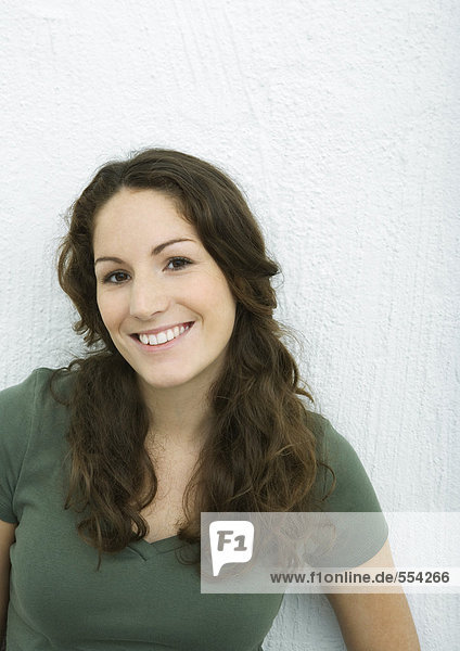 Junge Frau lächelt vor der Kamera  Porträt  weißer Hintergrund