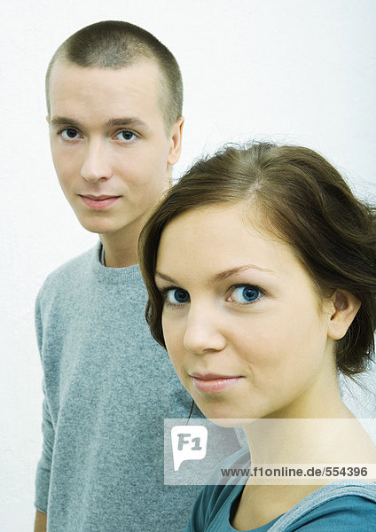 Young woman and young man  looking at camera  portrait