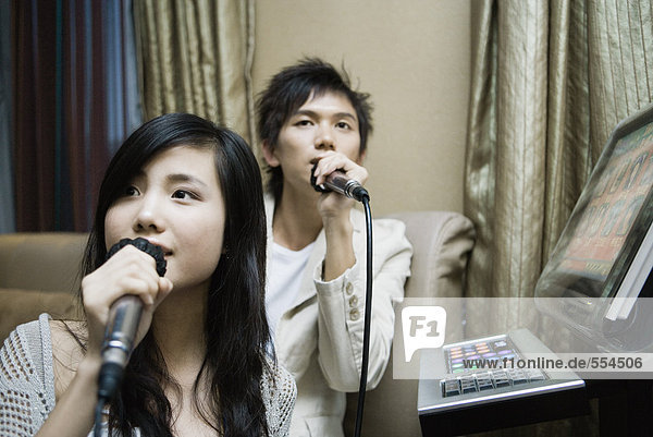 Junges Paar singt Karaoke