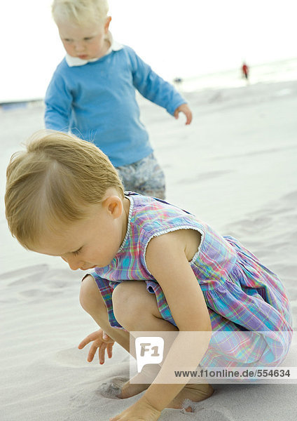 Zwei Kleinkinder beim Spielen am Strand