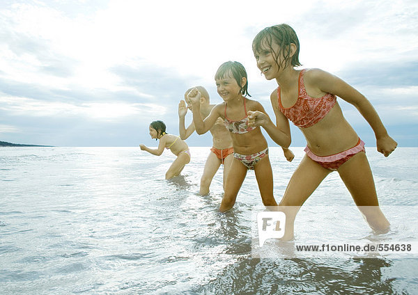 Vier Mädchen stehen im flachen Wasser  posiert zum Rennen