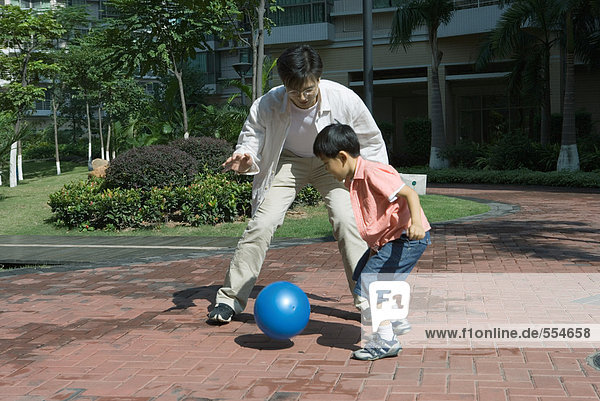 Vater und Sohn beim Ballspielen im Hof