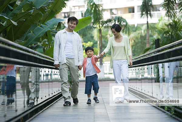 Boy walking with parents  full length  front view