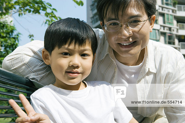 'Father and son  boy making ''v'' sign with fingers'