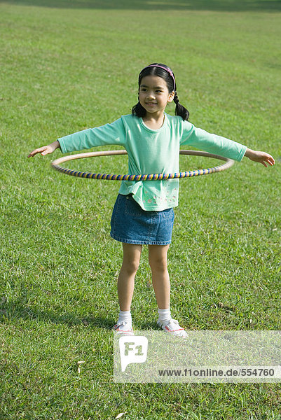 Mädchen spielt mit Kunststoffreifen