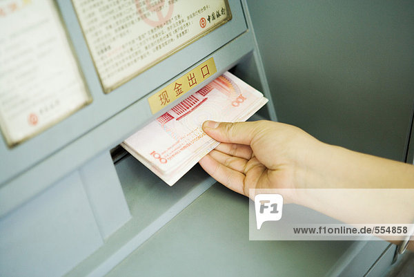 Person  die Banknoten von Geldautomaten  abgeschnittene Ansicht nimmt