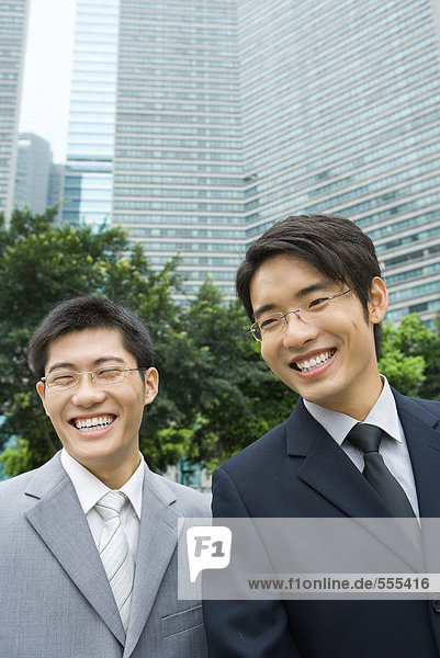 Zwei junge Geschäftsleute  lachend  Bürogebäude im Hintergrund