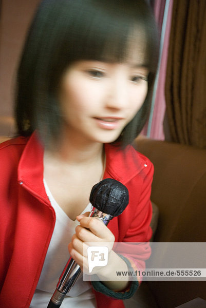 Young woman holding microphone  blurred motion