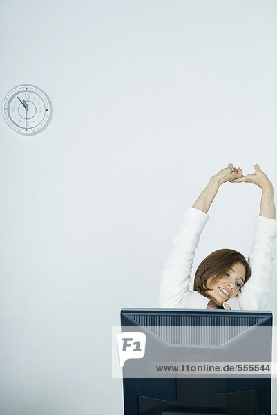 Businesswoman stretching at desk