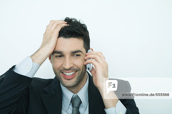 Businessman using cell phone  holding head