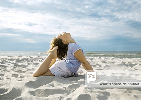 Mädchen beim Yoga posieren am Strand