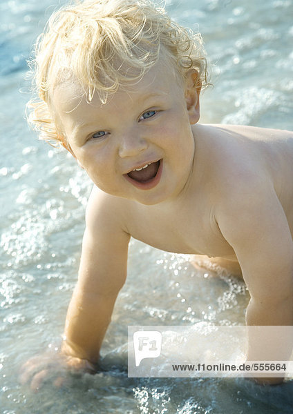 Kleinkind beim Surfen  lächelnd vor der Kamera  Porträt
