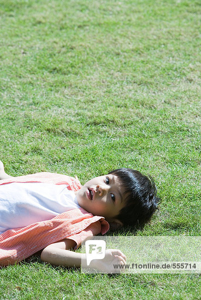 Junge auf Gras liegend