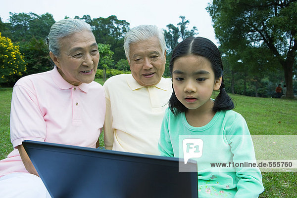 Mädchen und Großeltern mit Laptop