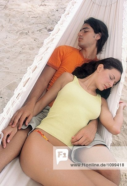 Couple sleeping in a hammock at the beach