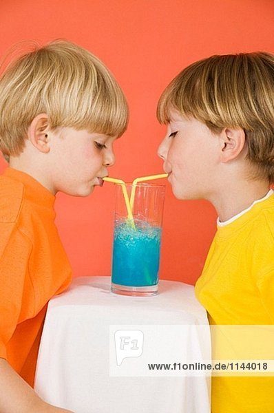 Zwei Jungen Trinken Blaue Limonade Durch Strohhalme Aus Der Gleichen Glas Teilen