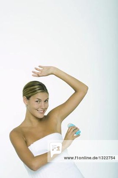 Woman putting on deodorant