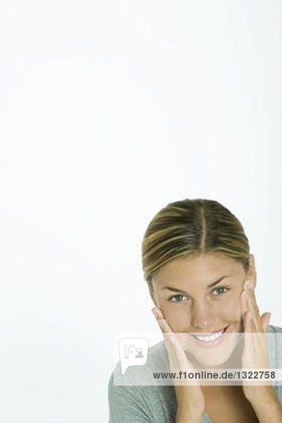 Woman washing face  smiling at camera