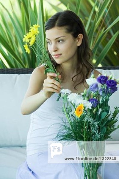 Junge Frau macht frisches Blumenarrangement