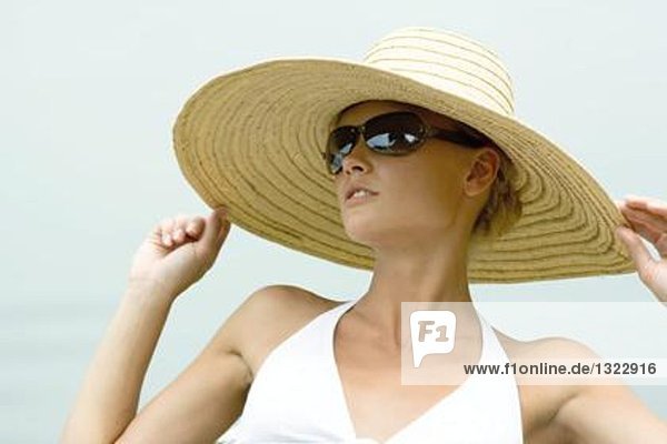 Junge Frau mit Sonnenhut und Sonnenbrille