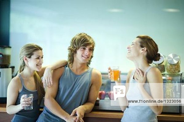 Junge Erwachsene in Sportbekleidung machen Pause in der Cafeteria des Fitnessclubs