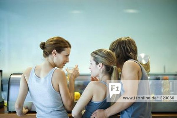 Junge Erwachsene in Sportbekleidung  Pause in der Cafeteria des Fitnessclubs