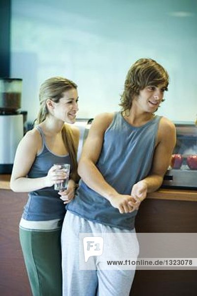 Young adults in exercise clothing  taking break in health club cafeteria