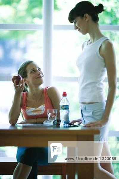Junge Frauen in Sportbekleidung  Chatten in der Cafeteria des Fitnessclubs