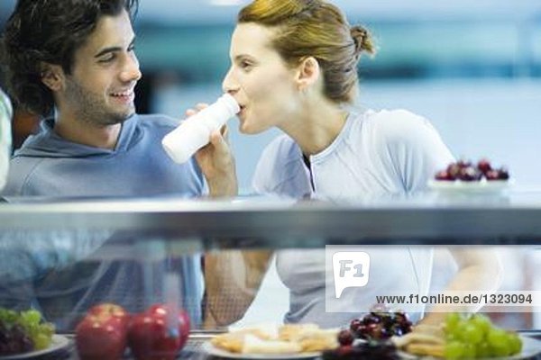 Junge Erwachsene in Sportbekleidung  Snack in der Fitness-Cafeteria