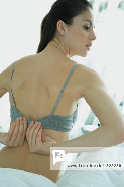 Woman fastening bra  rear view