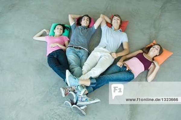 Teenager-Freunde auf dem Boden liegend mit Beinen an den Knöcheln verbunden